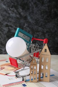 Petit caddy avec une ampoule et une calculatrice, ainsi que des billets representant les economies faites