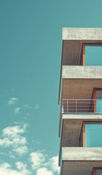 Elegant shot of a high-rise building nearing completion, set against a clean, neutral backdrop,